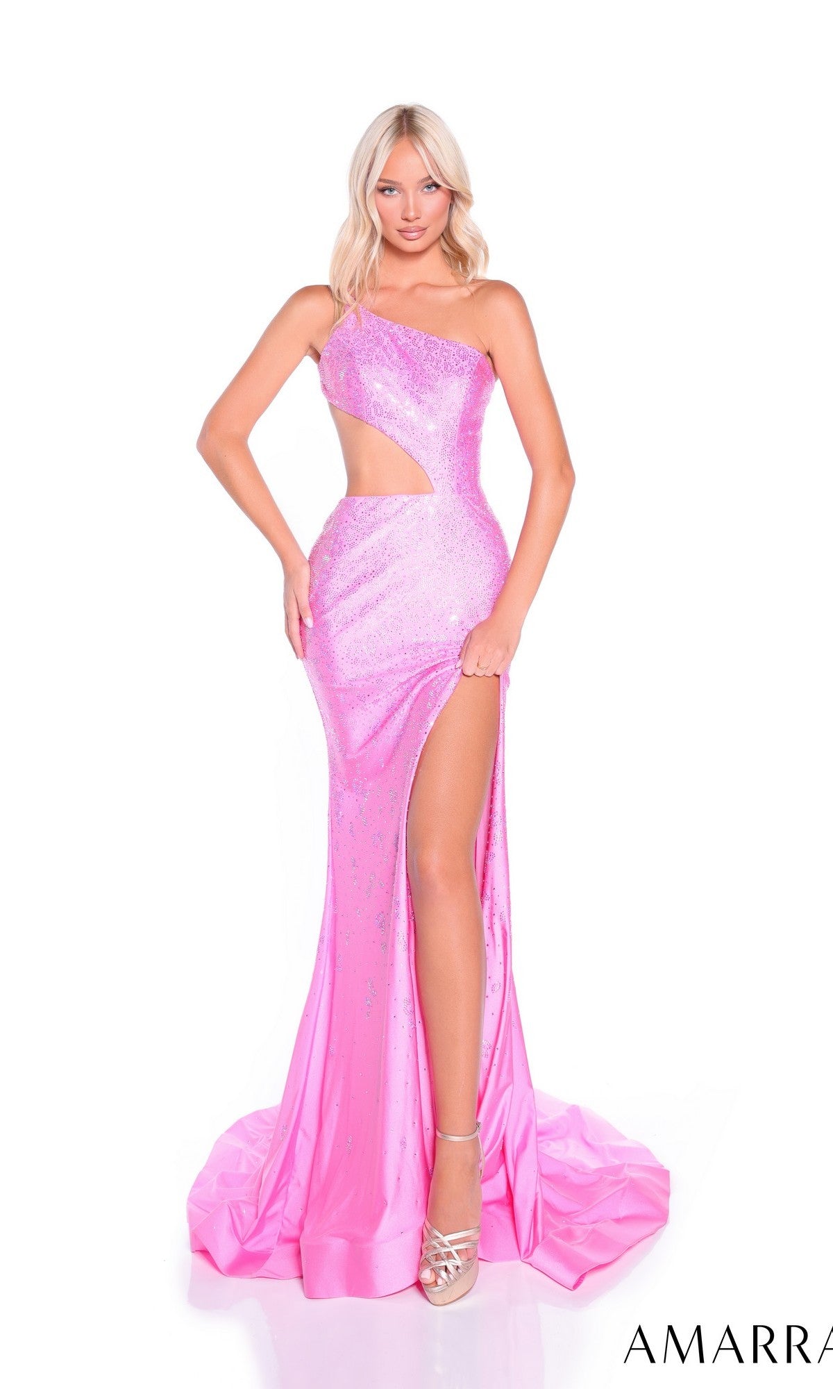 A woman poses in the Amarra 89323 long prom dress, a shiny pink one-shoulder gown with hot stone embellishments, side cutout, high slit, and floor-length train. She finishes the look with silver high heels.